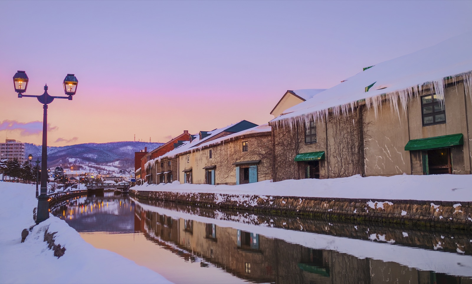 夕光映照小樽運河、雪地倉庫與亮起的街燈